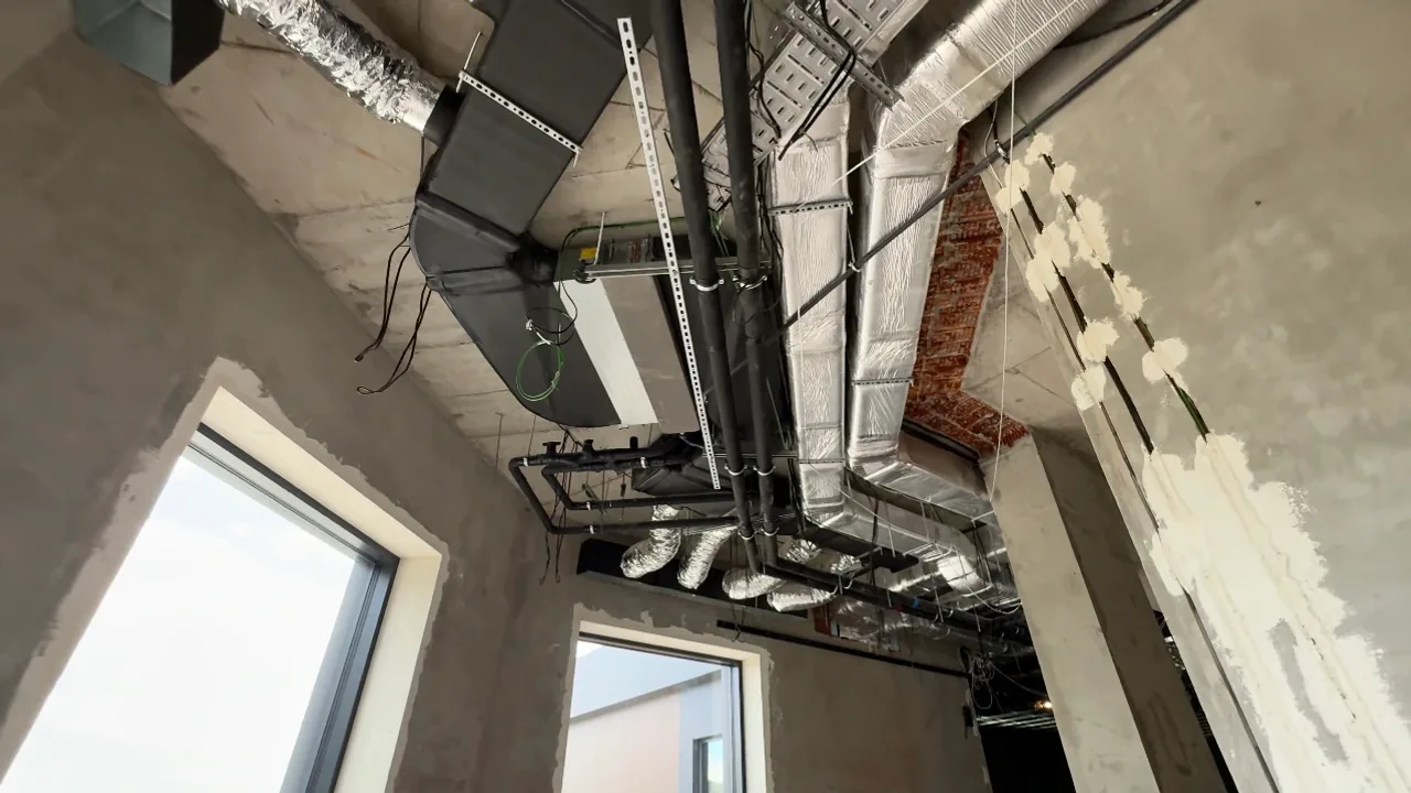 Підстельове розведення повітропроводів і обладнання вентиляції у житловому приміщенні на етапі монтажу.