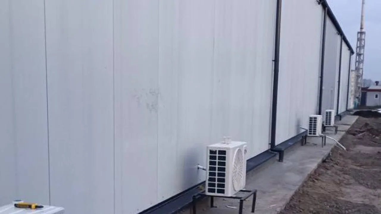 Side view of a cassette air-conditioning unit with insulated copper lines and a drain system connected.